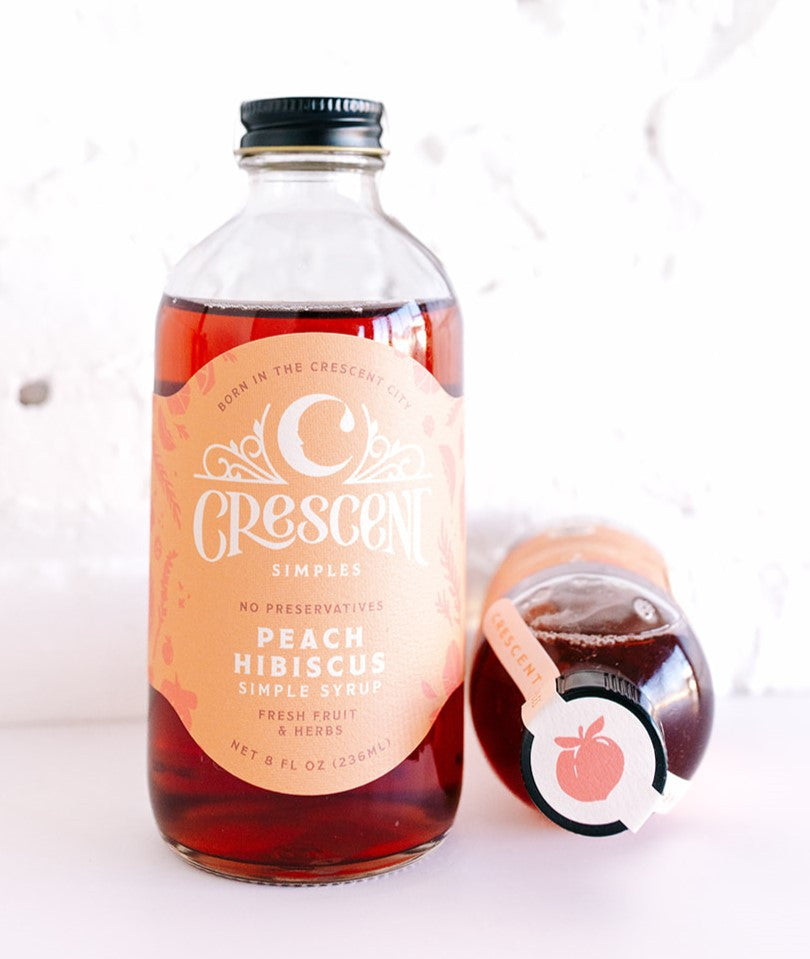 Crescent Simples Peach Hibiscus simple syrup in glass bottle with black cap