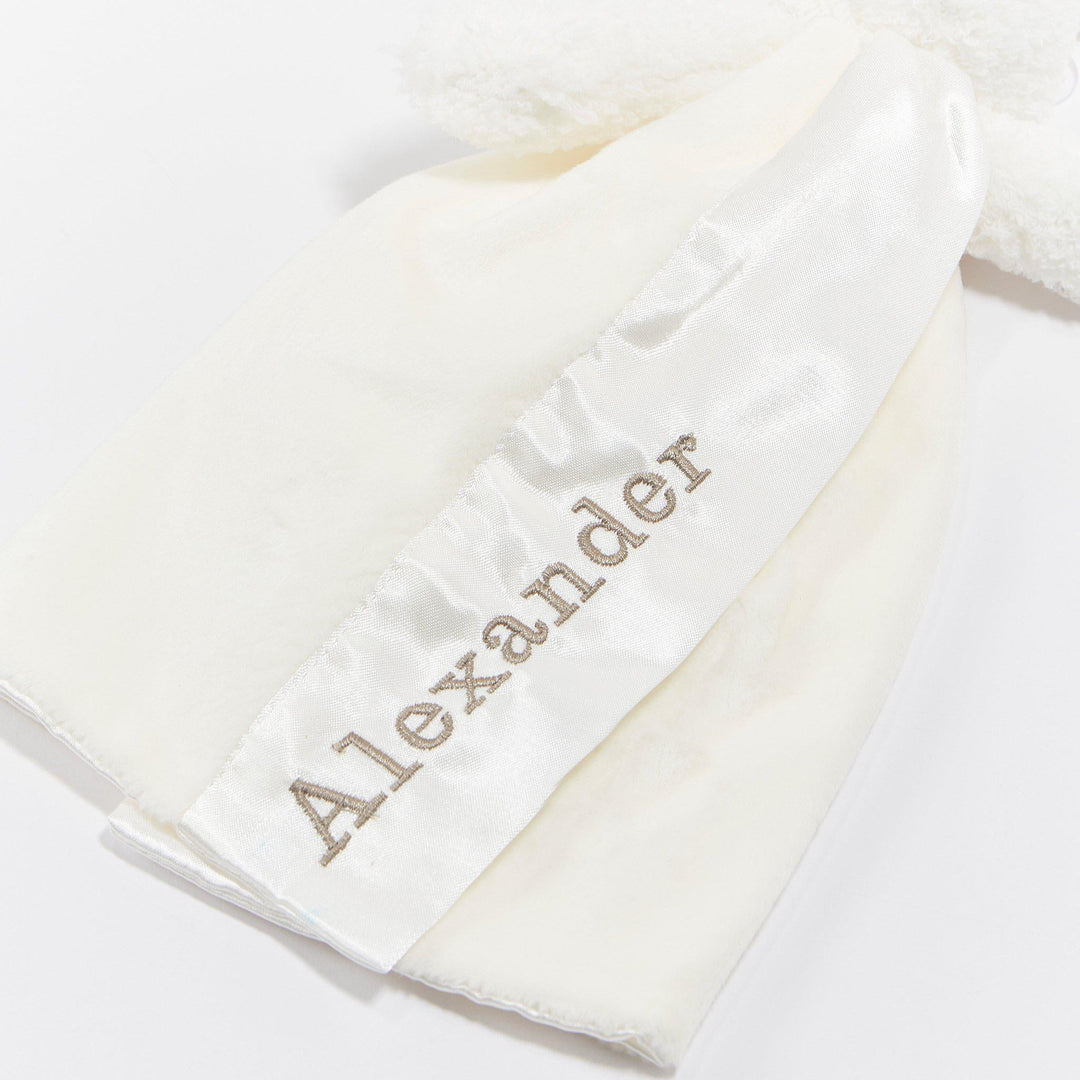 Close-up detail of white Bunnies By the Bay Bun Bun Bunny Bye Bye Buddy with embroidered satin name tag reading Alexander