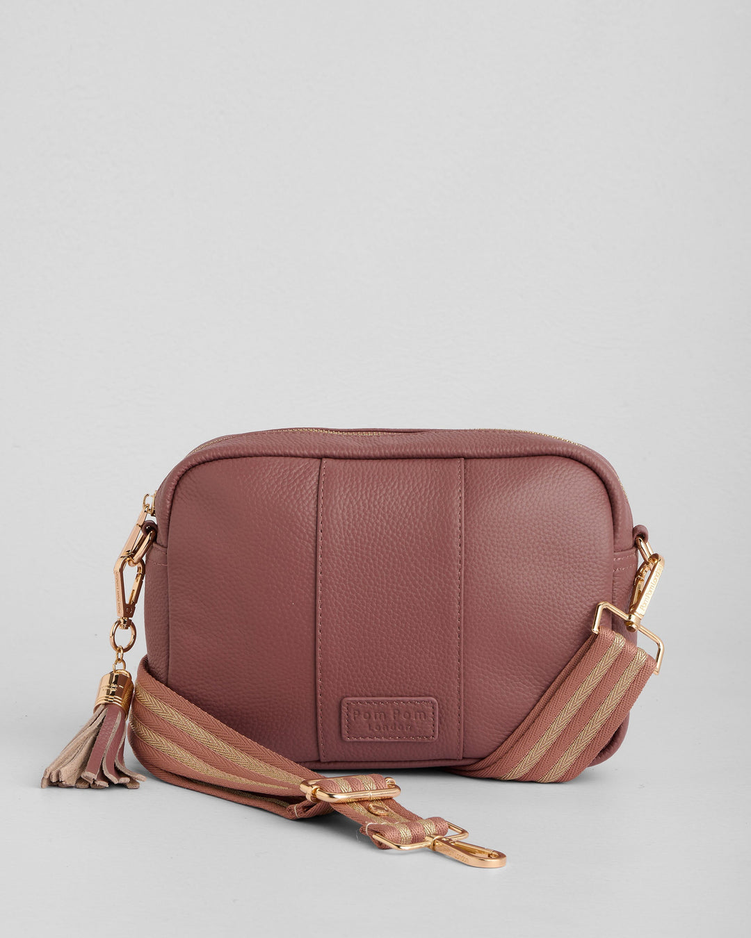 Pom Pom London dusty pink leather crossbody bag with striped strap and tassel detail