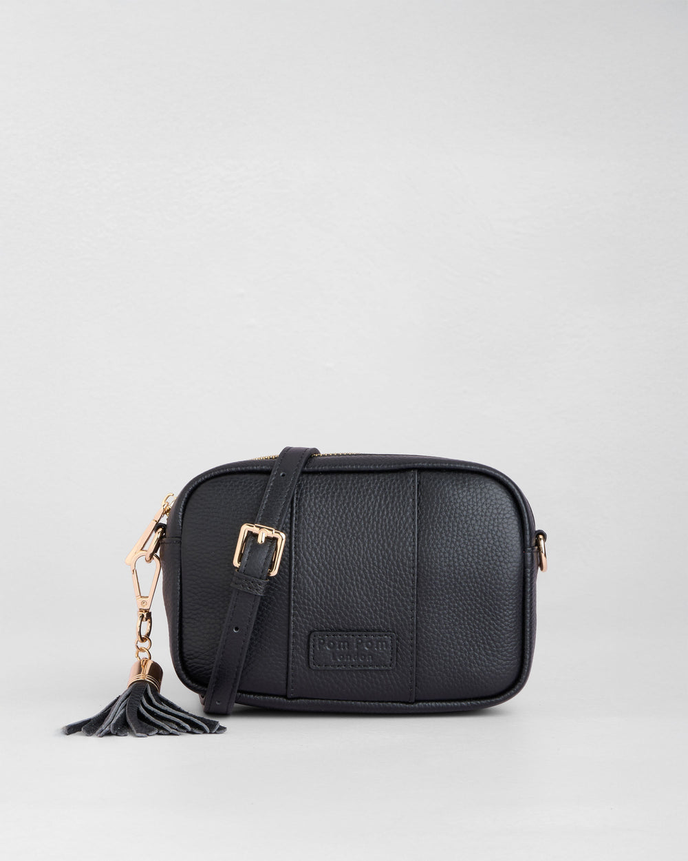 Black leather crossbody bag with tassel detail and adjustable strap