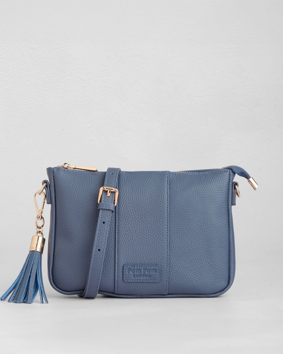 Pom Pom London City Slim crossbody bag in slate blue leather with tassel detail