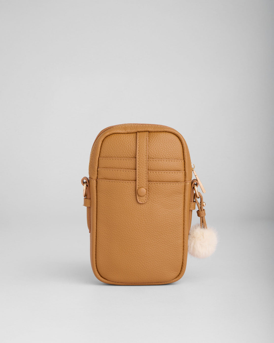 Pom Pom London Eaton Phone Bag in camel brown leather with white pom pom charm