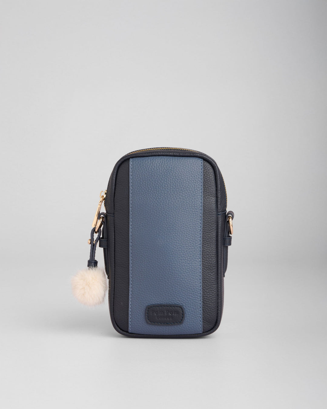 Pom Pom London Eaton phone crossbody bag in navy and black with white pom pom charm