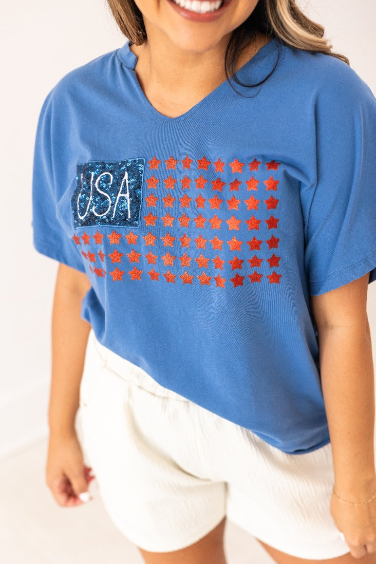 Blue v-neck t-shirt with USA flag design featuring glitter stars and stripes