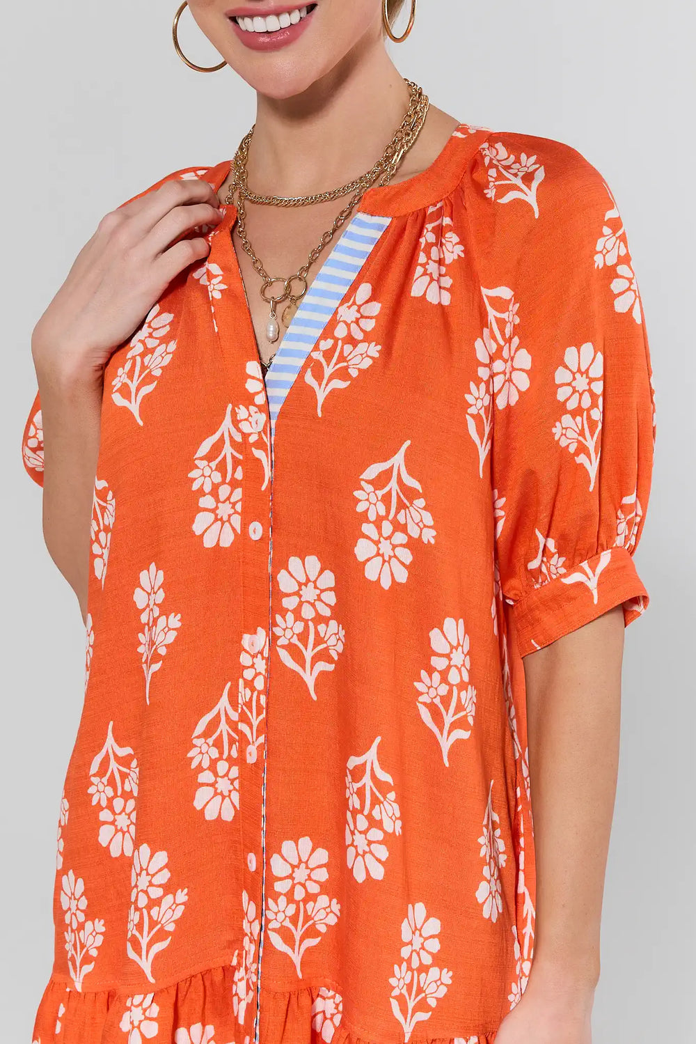 Orange floral button-up dress with short sleeves and white flower print pattern