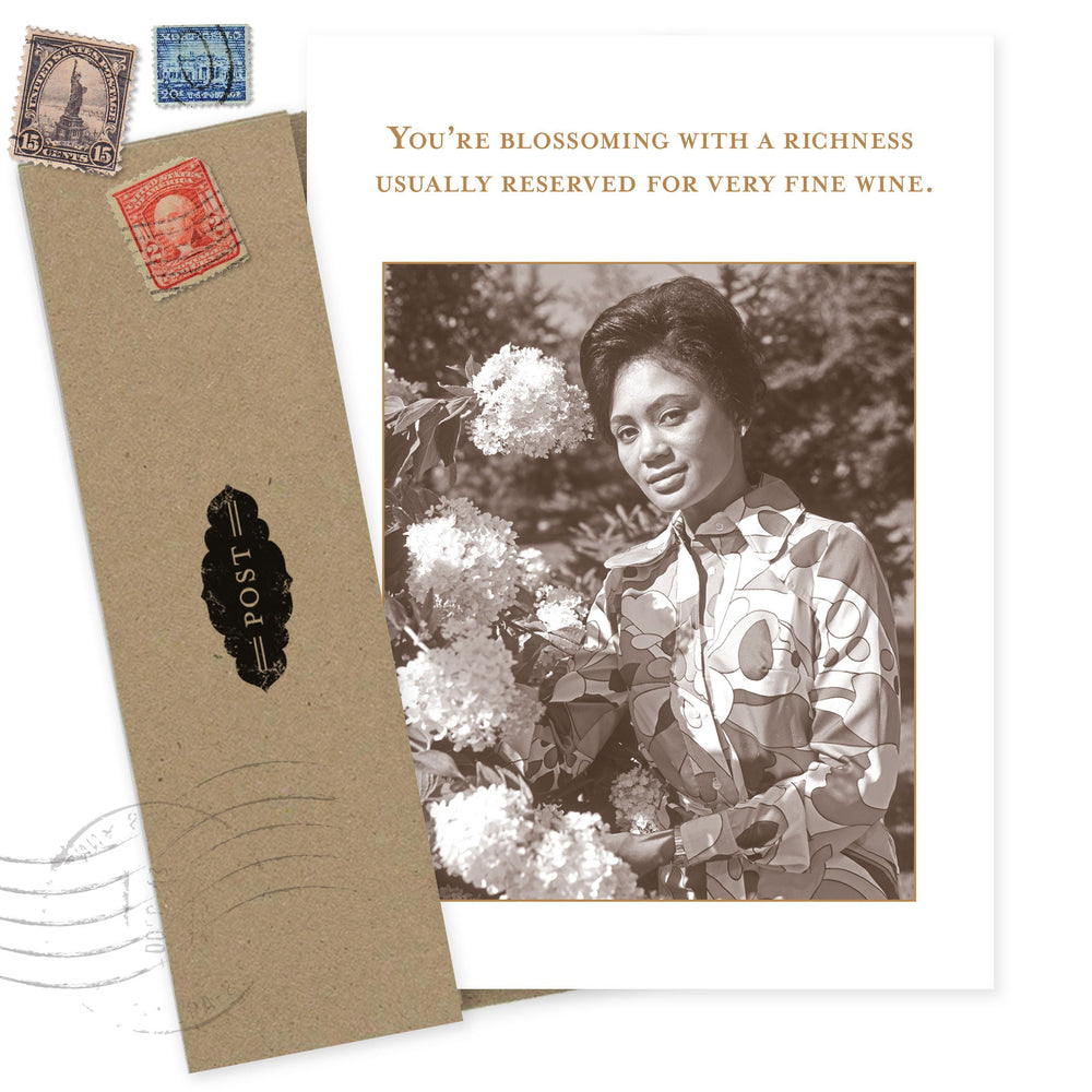 Vintage-style birthday card with woman holding flowers and inspirational wine quote text