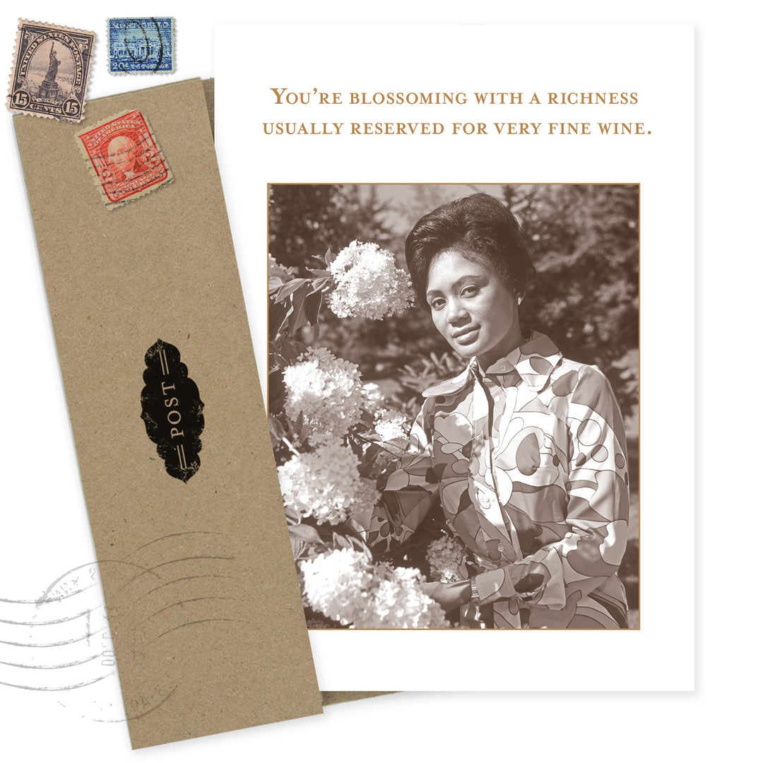 Vintage-style birthday card with woman holding flowers and inspirational wine quote text
