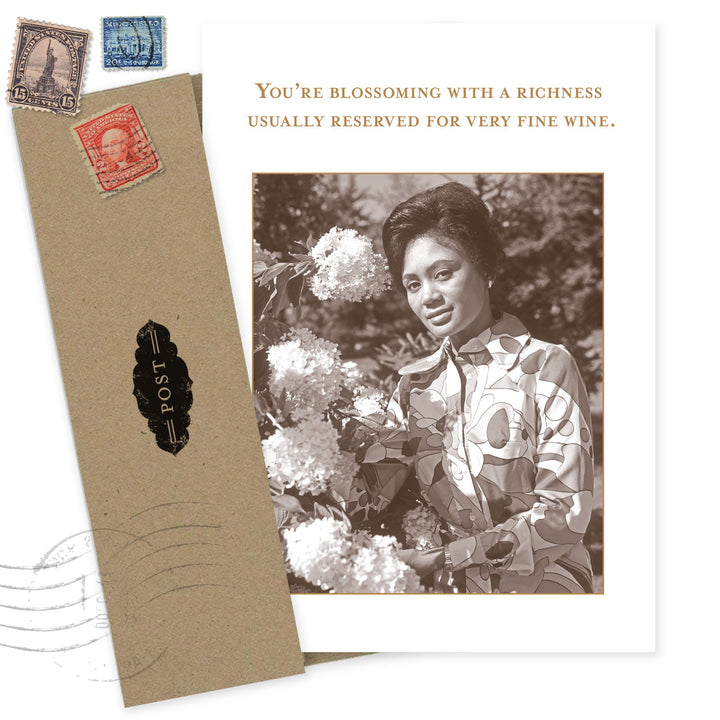 Vintage-style birthday card with woman holding flowers and inspirational wine quote text