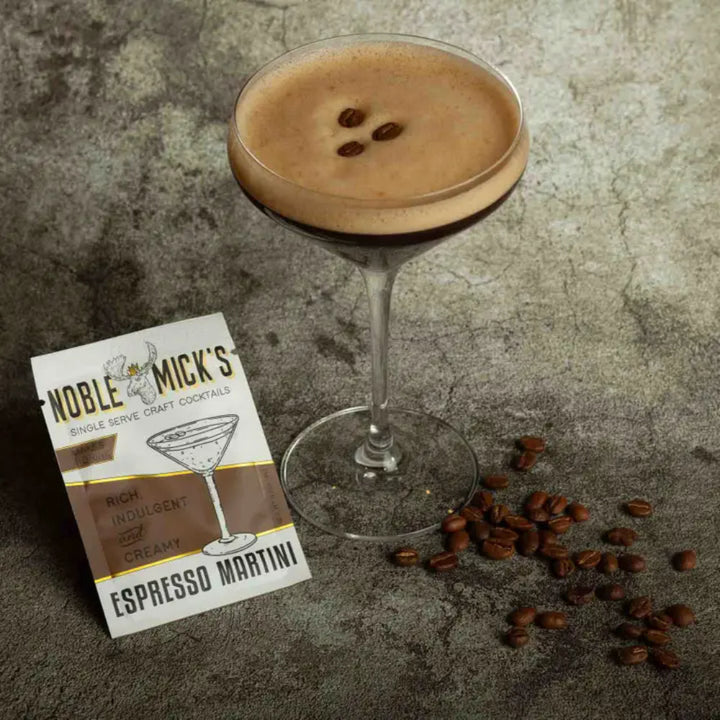 Noble Mick's Espresso Martini single serve craft cocktail packet beside a frothy espresso martini glass
