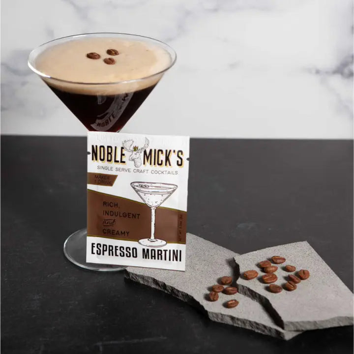 Noble Mick's Espresso Martini single serve craft cocktail mix packet beside a freshly made cocktail