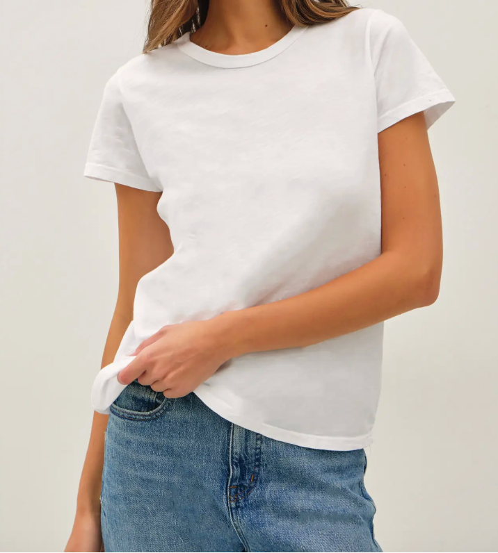 Woman wearing white cotton slub t-shirt with blue jeans against neutral background