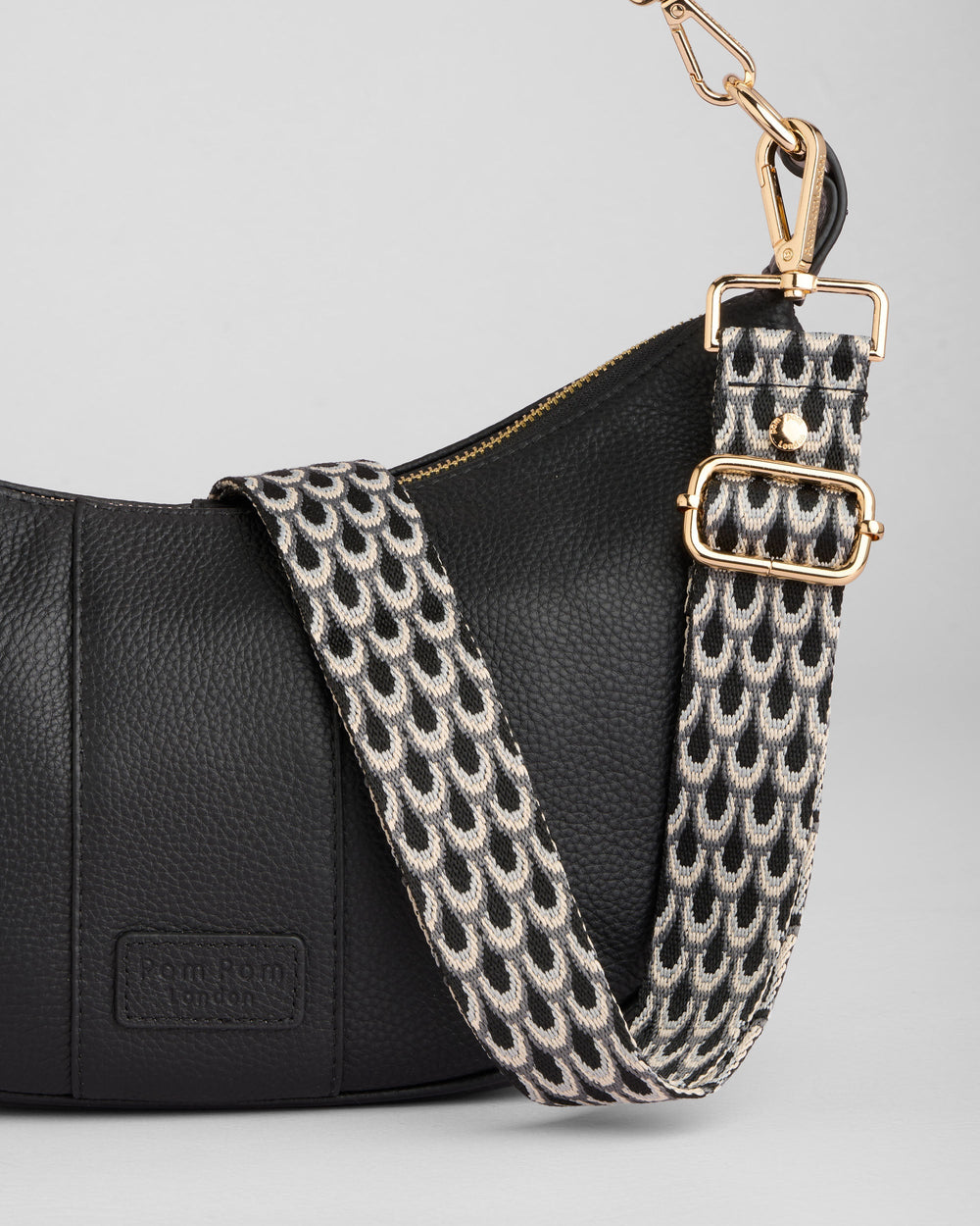 Black leather Pom Pom London Sutton Sling Bag with geometric patterned shoulder strap