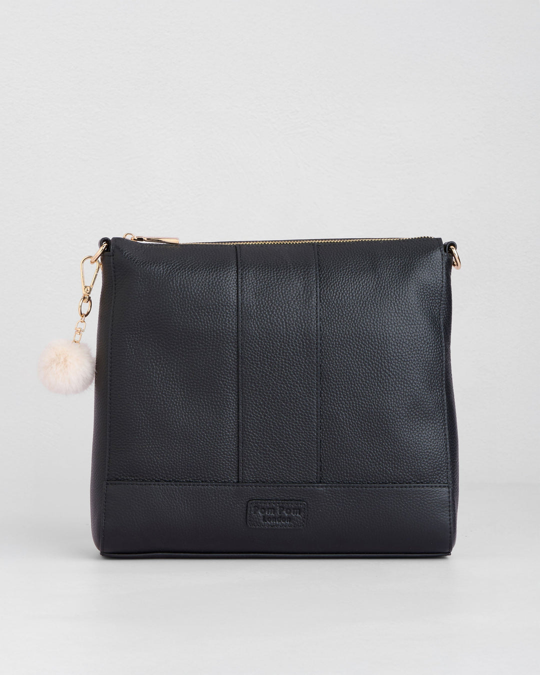 Black Westminster crossbody bag by Pom Pom London with pink pom pom charm