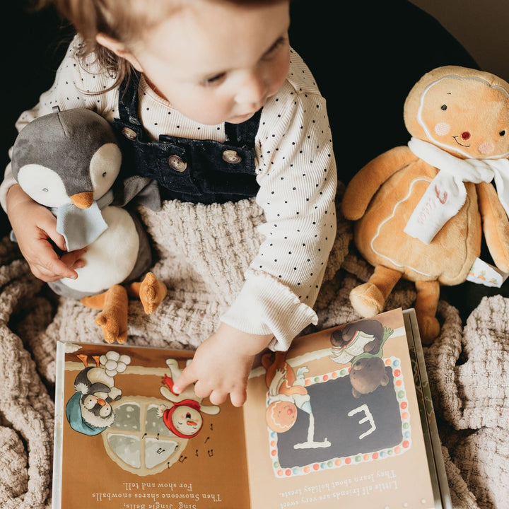Child reading Bunnies by the Bay Elf-A-Mentary School holiday picture book with plush toys