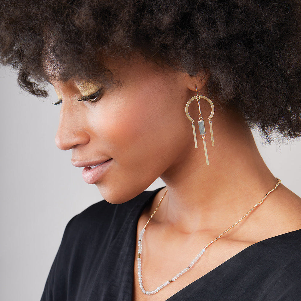 Woman wearing Scout Dream Stone earrings with gold circles and labradorite stone dangles