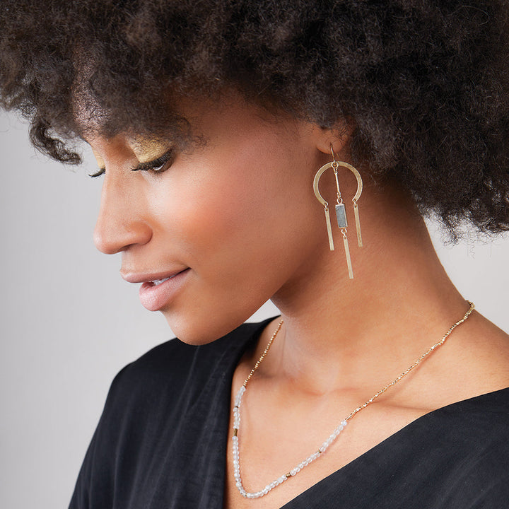 Woman wearing Scout Dream Stone earrings with gold circles and labradorite stone dangles