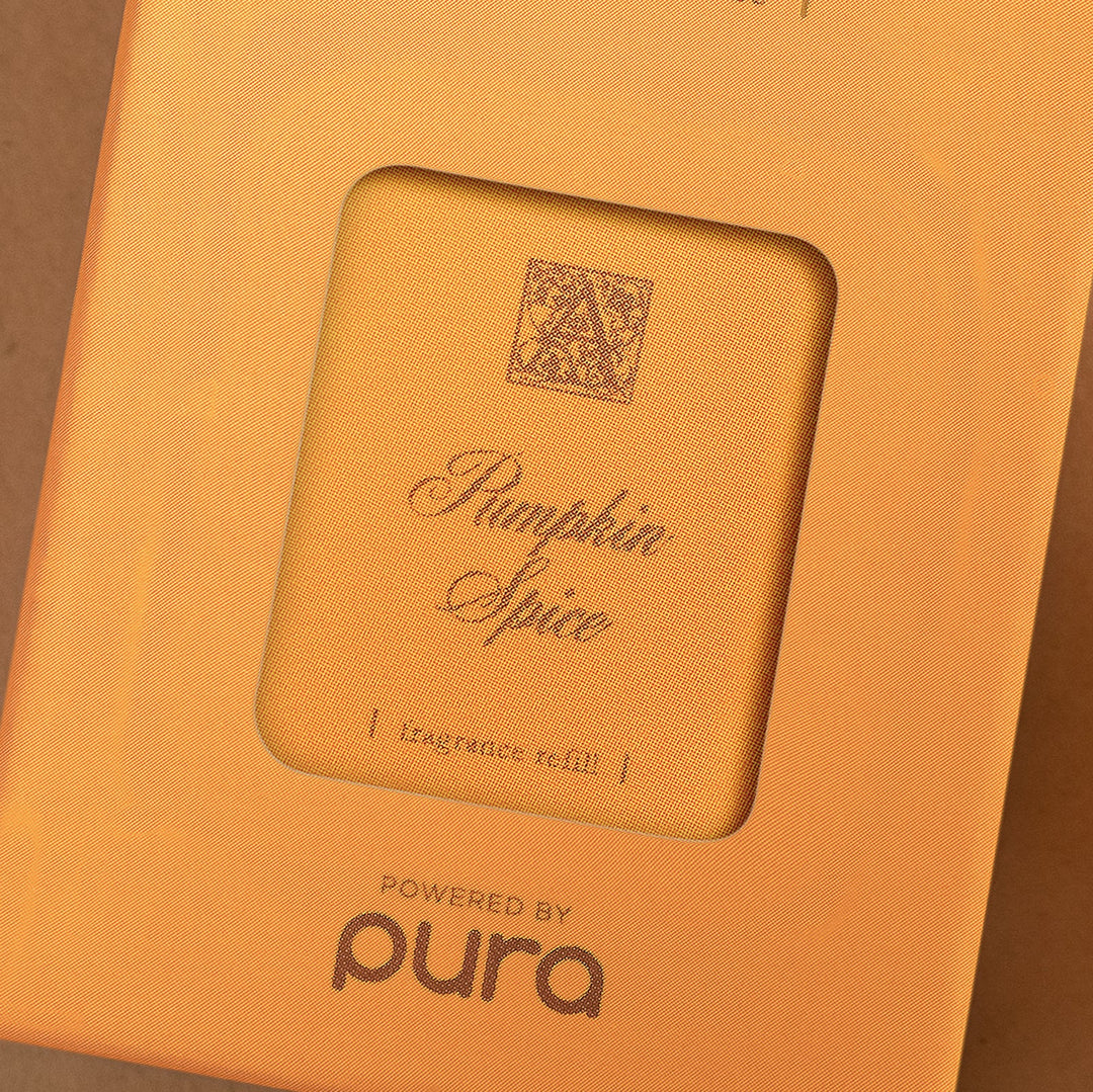 Pura Pumpkin Spice fragrance refill smart vial in orange seasonal packaging by Pura Scents.