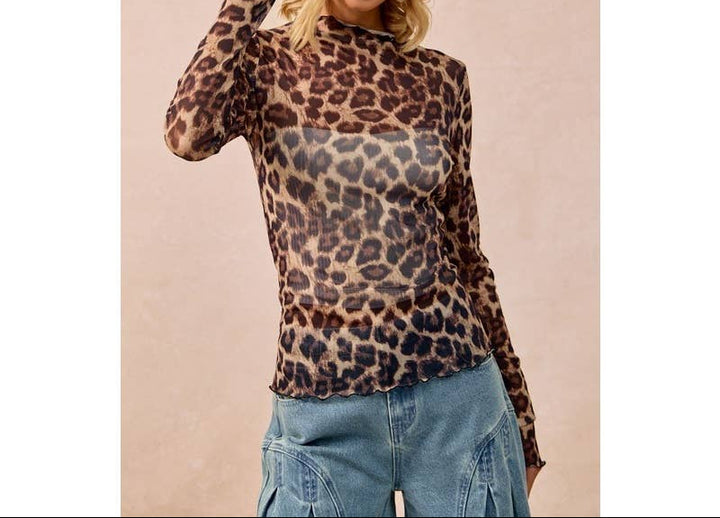 Woman wearing mesh leopard print long sleeve top with cowboy hat and jeans