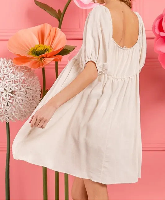 White tiered midi dress with puffy sleeves and open back on model