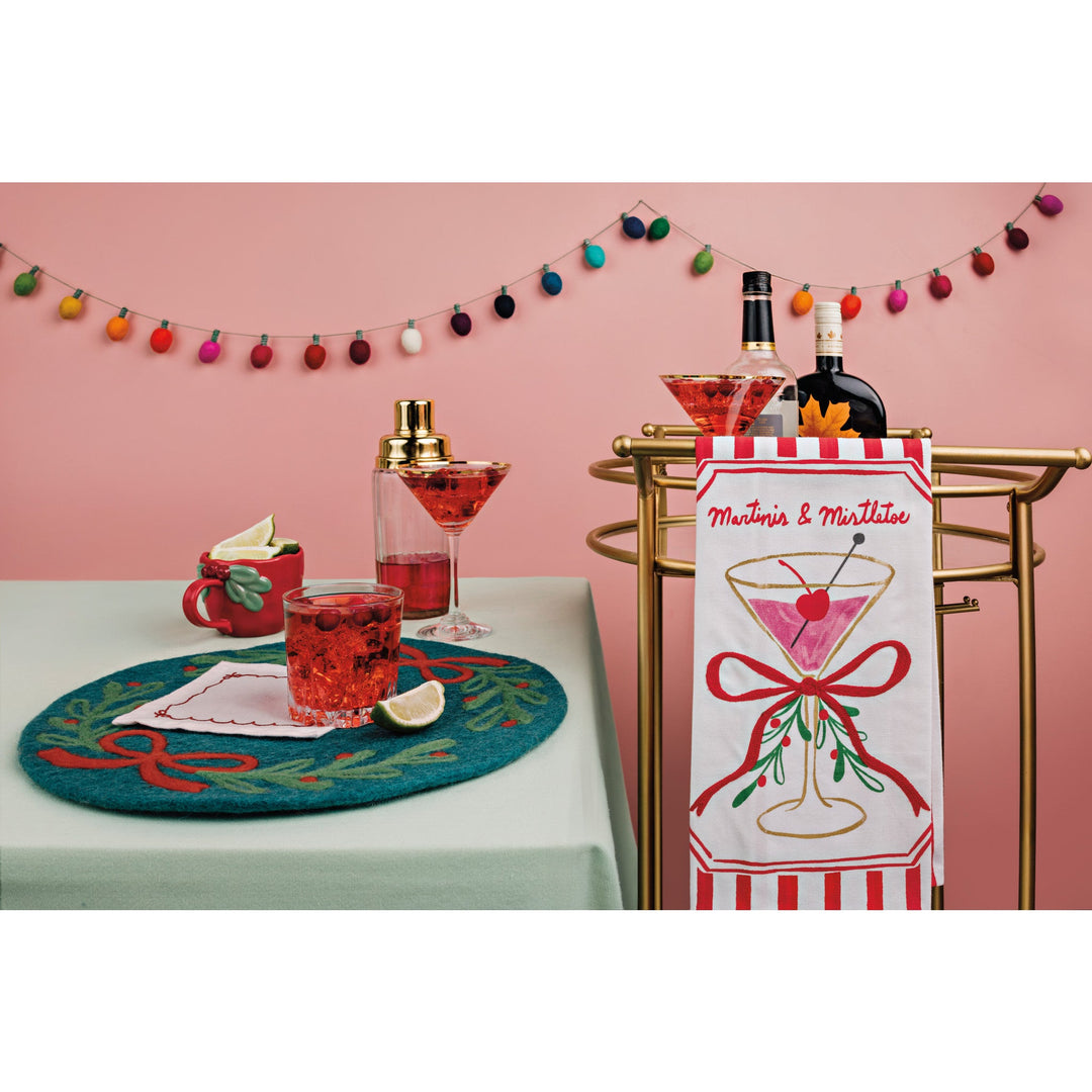 Red Christmas sculpted mug with mistletoe handle displayed on festive holiday table setting.