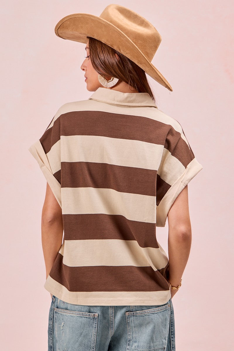 Woman wearing brown and cream striped short-sleeve top with rolled cuffs and hat
