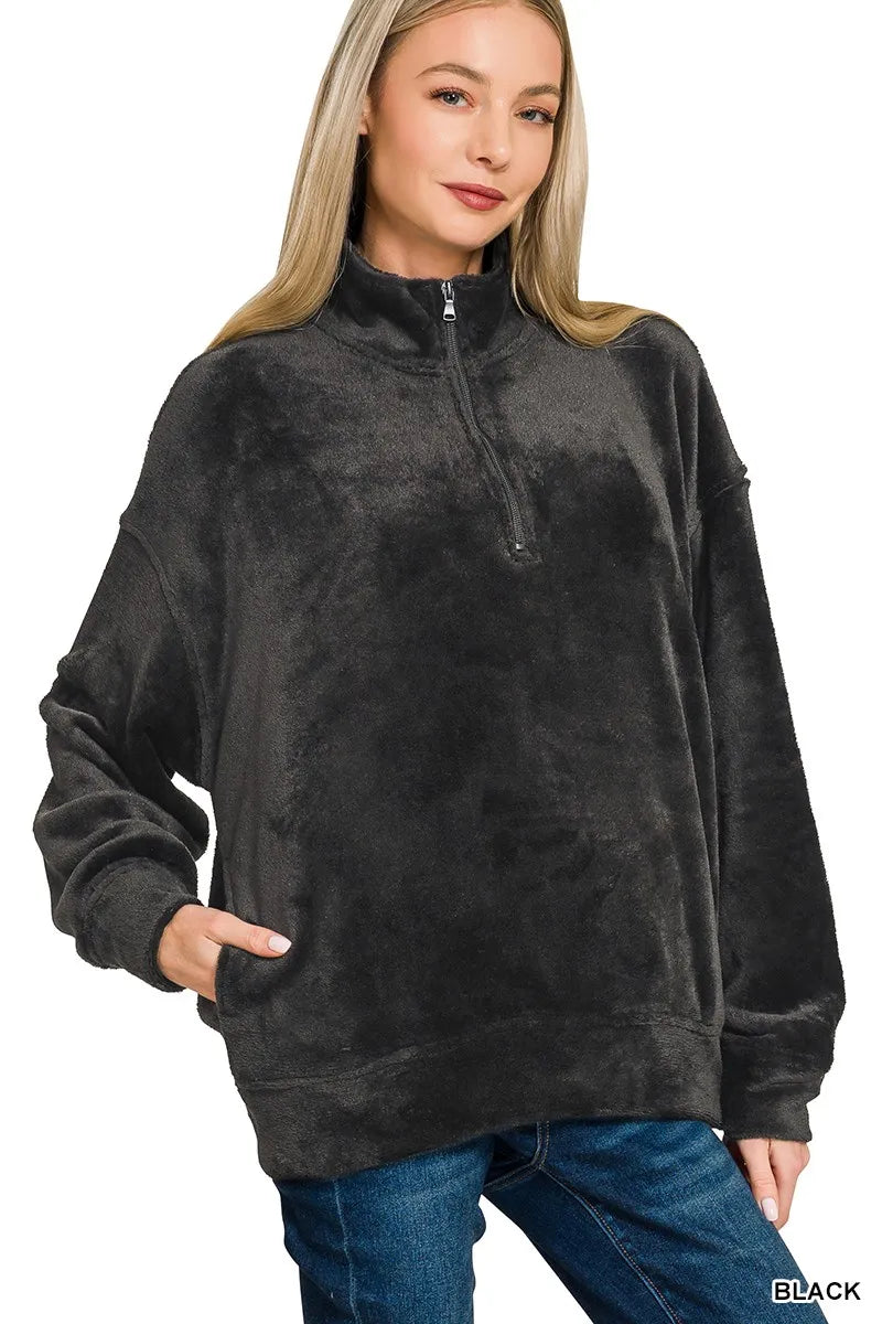 Woman wearing black faux fur half zip pullover sweatshirt with relaxed fit