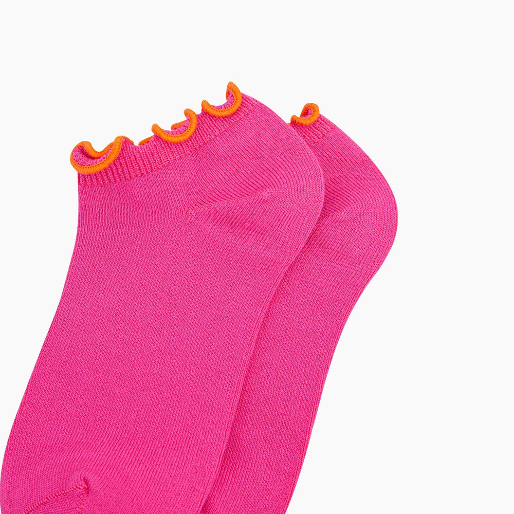 Bright pink bamboo trainer socks with orange frilly scalloped trim, shown as a pair.