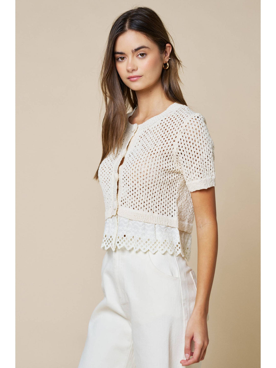 Woman wearing cream open knit short sleeve cardigan with lace trim detailing