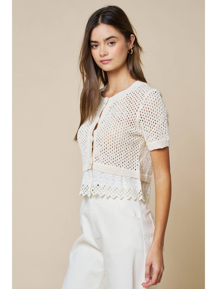Woman wearing cream open knit short sleeve cardigan with lace trim detailing