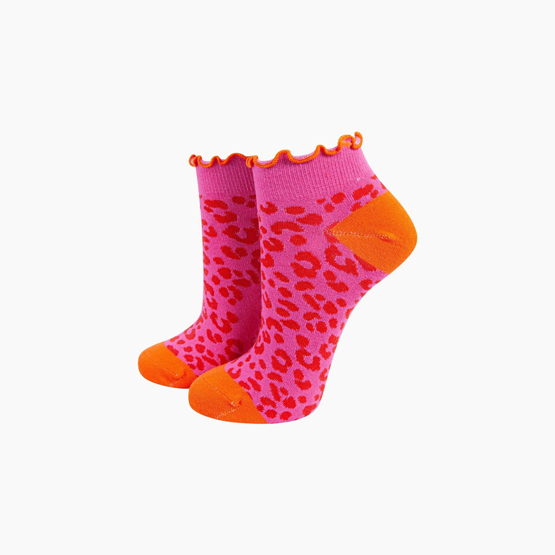 Pink leopard print ankle socks with orange toe, heel, and frilled cuff