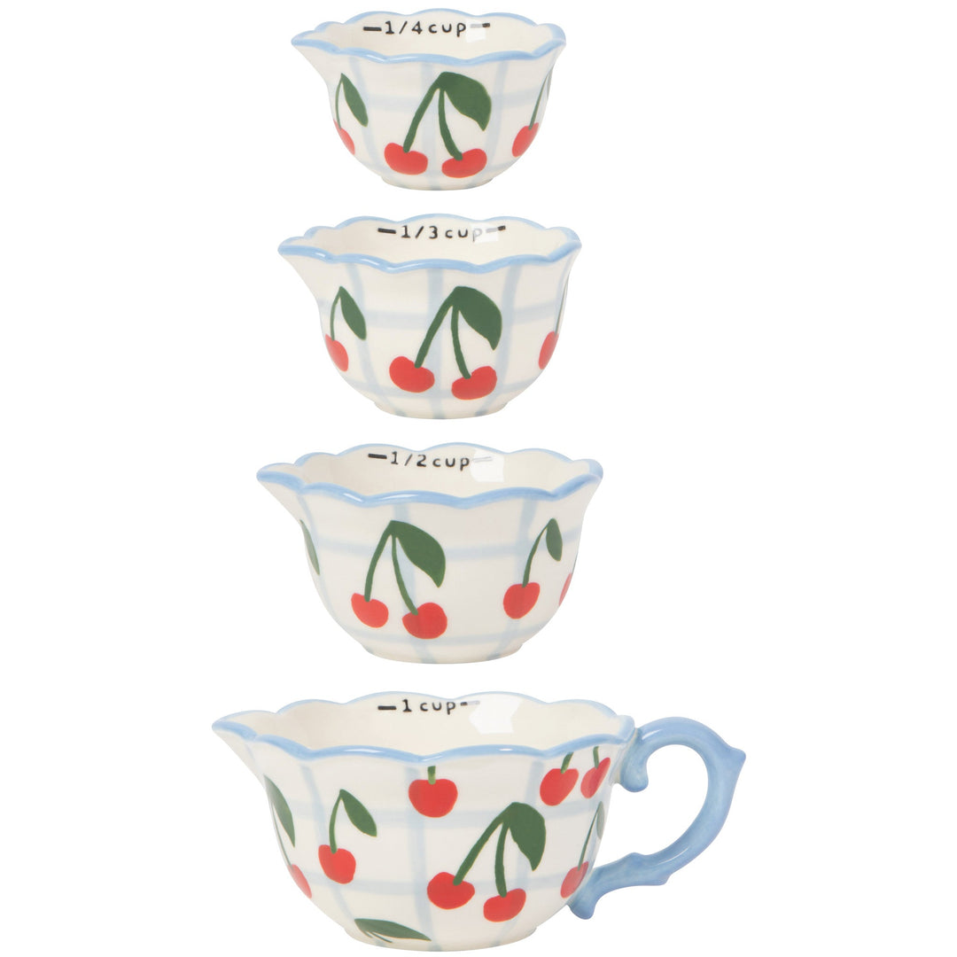 Set of four nested ceramic measuring cups with red cherry pattern and blue trim