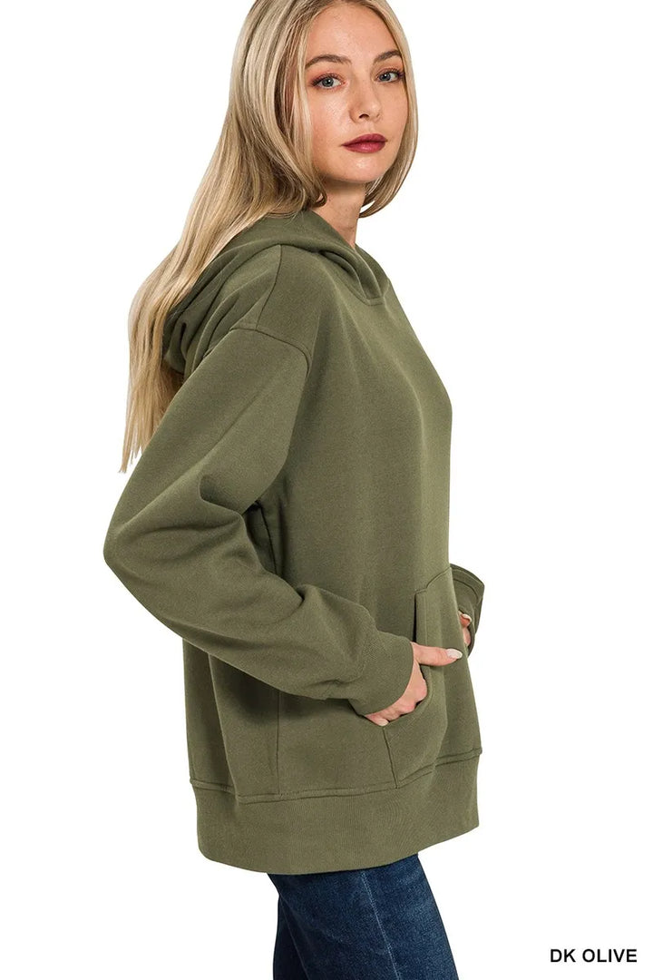 Woman wearing dark olive green fleece hoodie with kangaroo pocket and hood