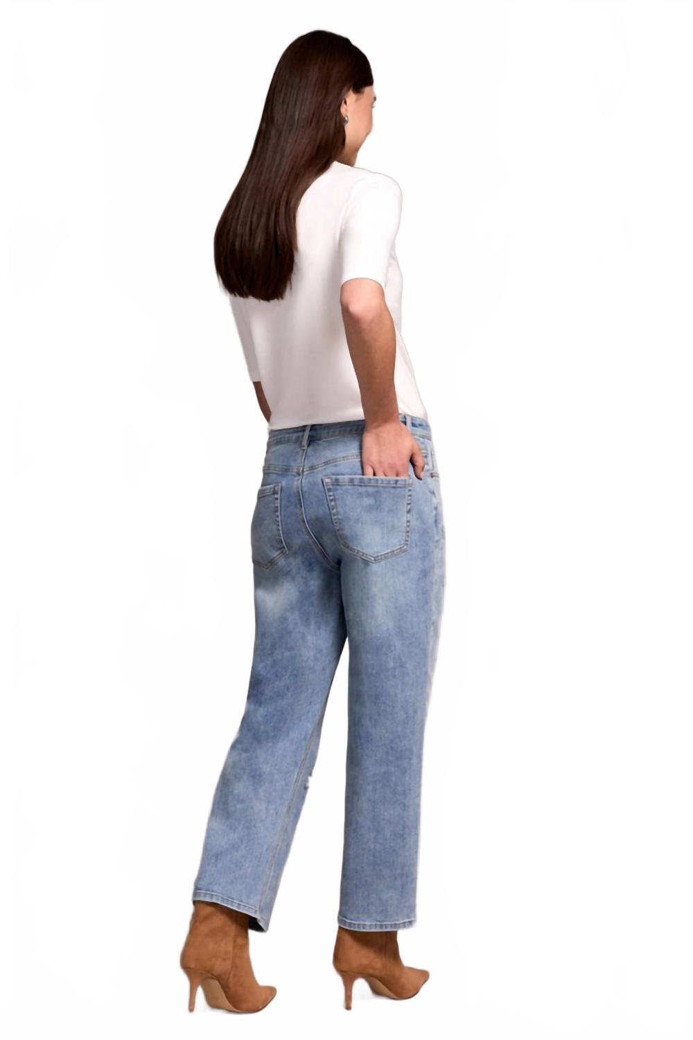 Woman wearing light washed blue straight leg flood jeans with white top, back view