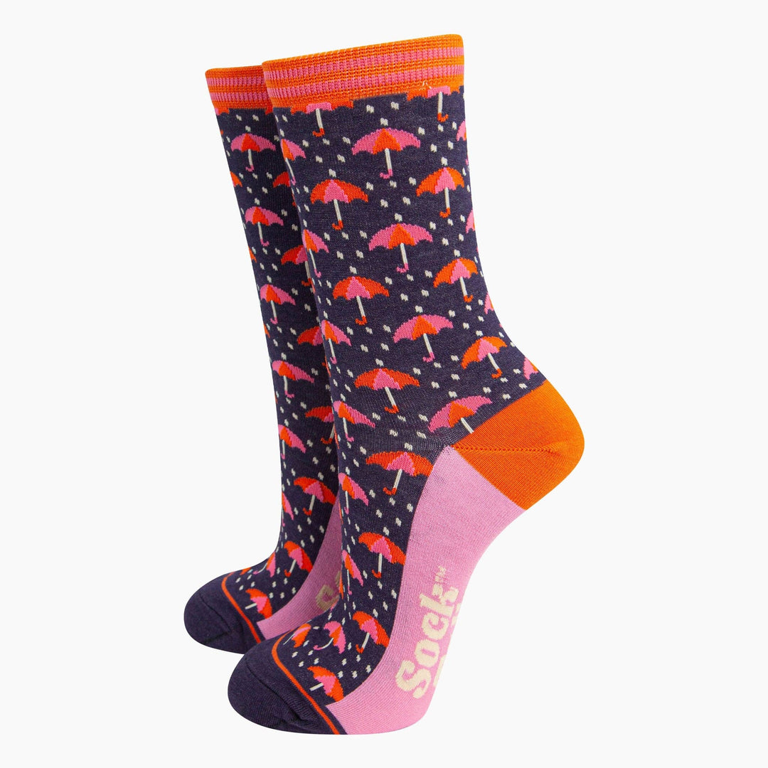 Navy blue bamboo crew socks with pink and orange umbrella rain pattern and orange heel