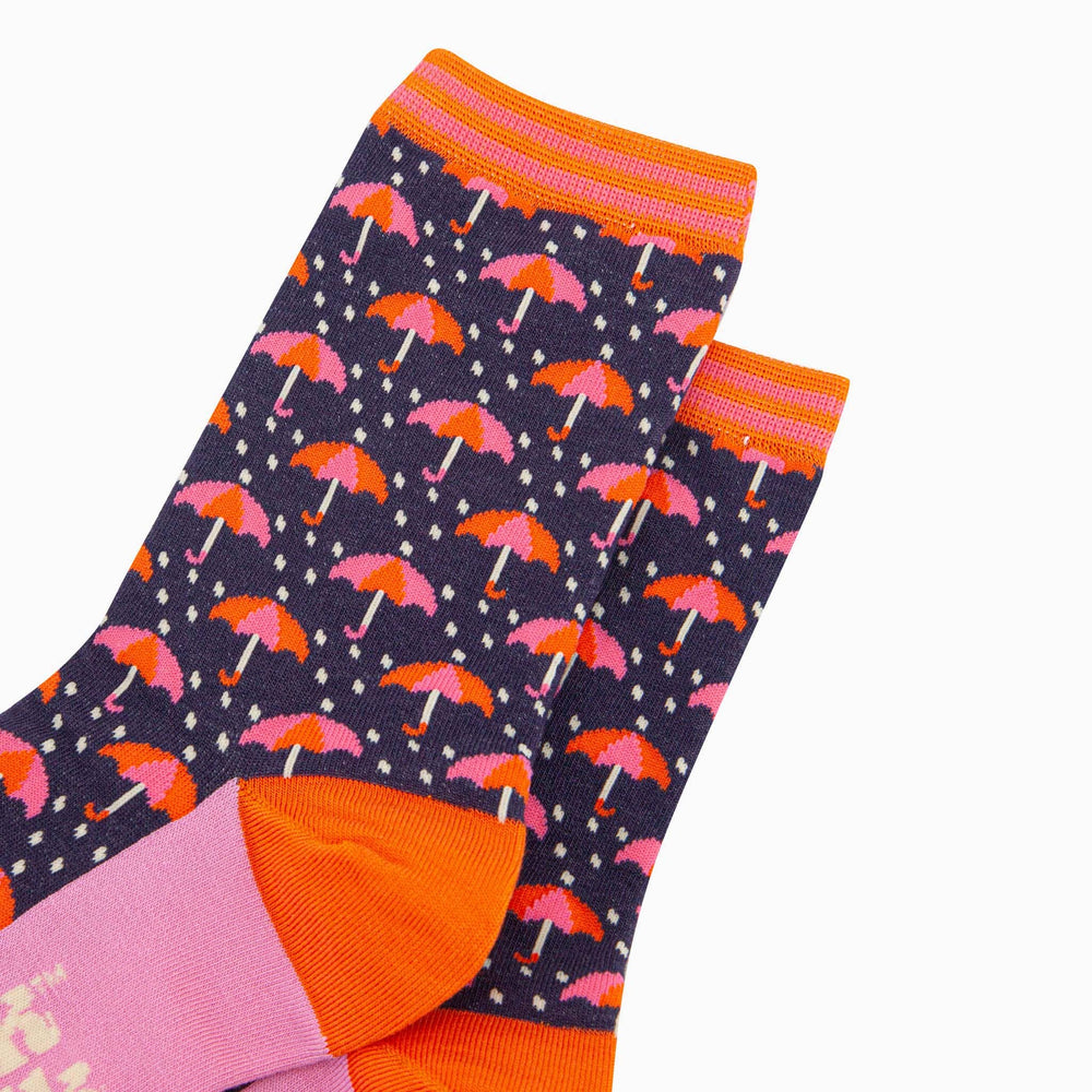 Navy blue bamboo crew socks with pink and orange umbrella pattern and striped cuff