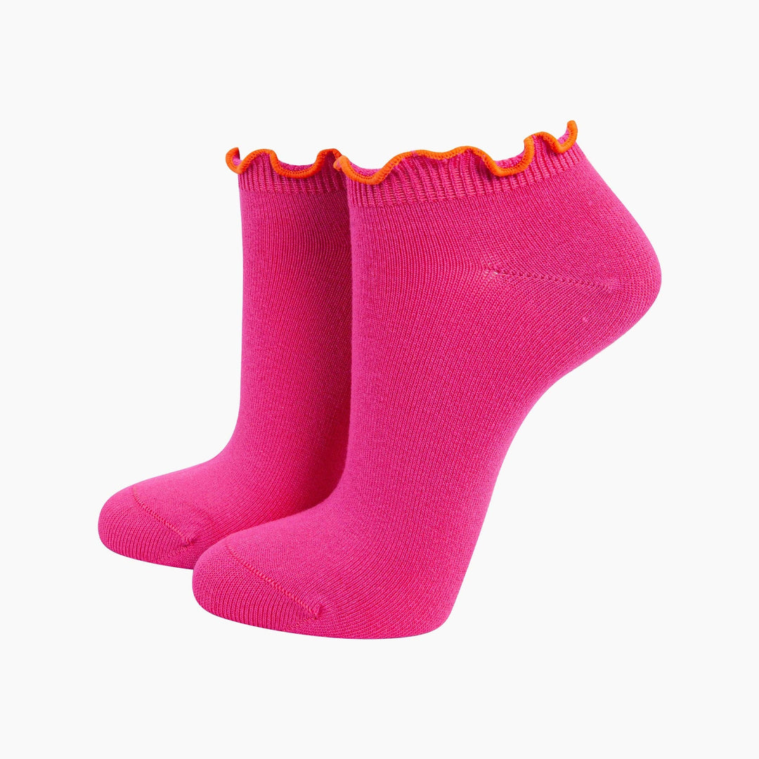 Hot pink bamboo trainer socks with frilly orange scalloped trim at ankle