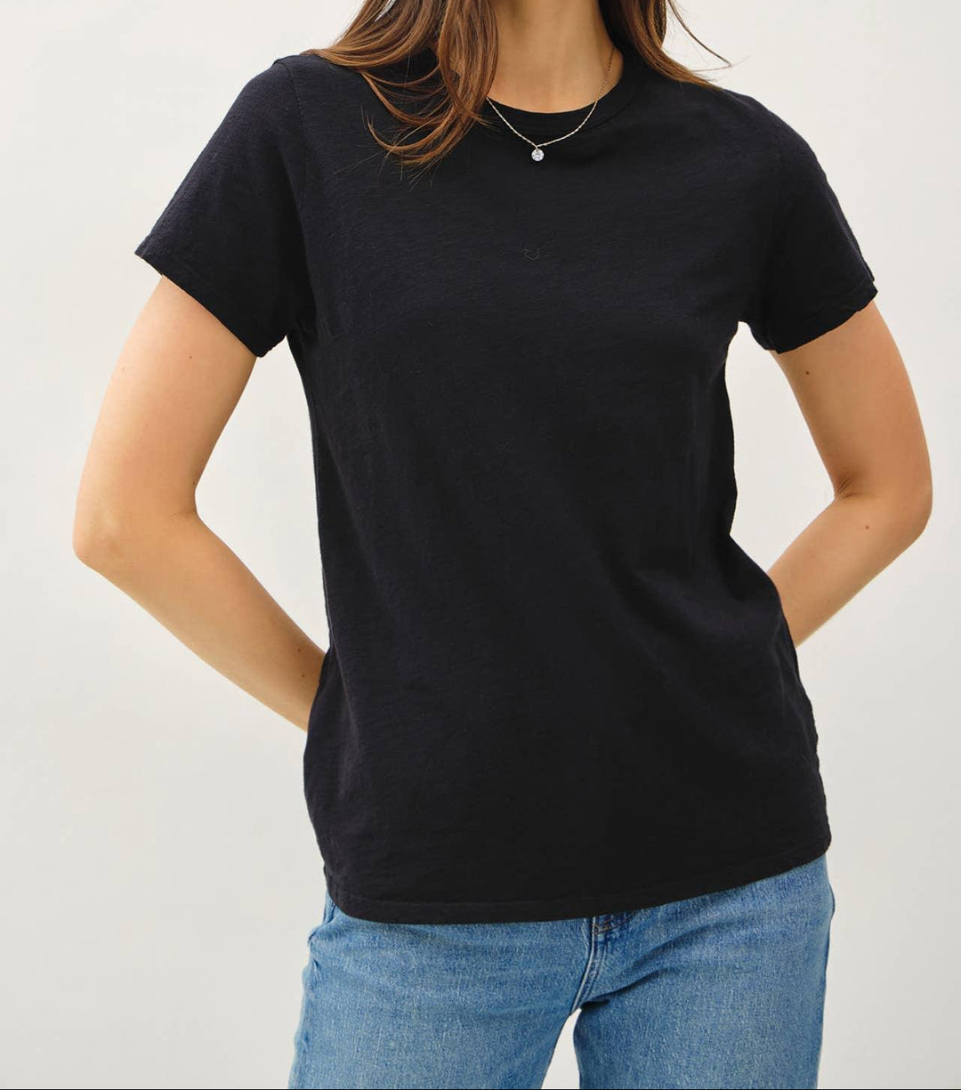 Woman wearing black cotton slub t-shirt with short sleeves and relaxed fit