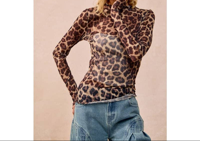 Woman wearing leopard print mesh long-sleeve top with cowboy hat and jeans