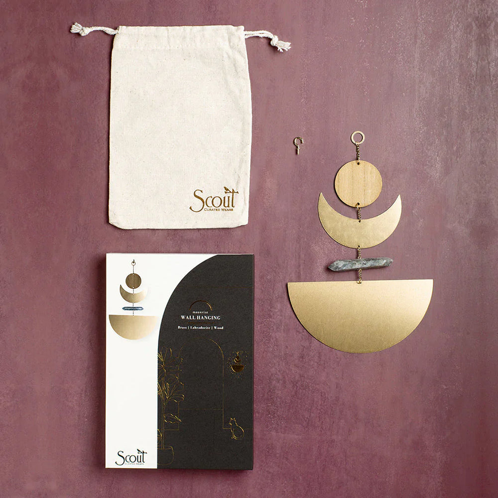 Scout brass geometric wall hanging with labradorite stone and packaging on burgundy background