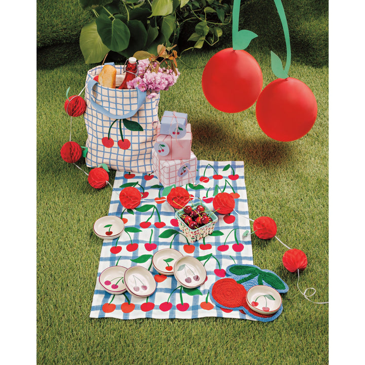 Danica pinch bowls with red cherry pattern displayed on picnic blanket