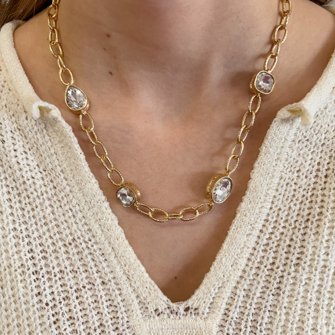 Gold chain necklace with clear crystal stones worn with cream knit top
