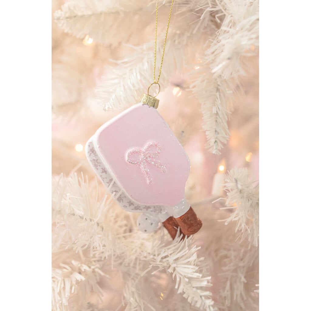 Pink pickleball paddle glass Christmas ornament with glitter bow hanging on white tree