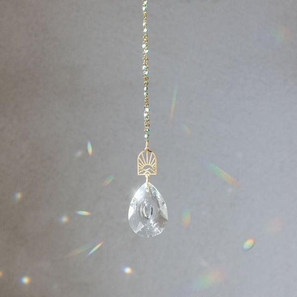 Scout suncatcher with clear crystal teardrop and gold chain creating rainbow light reflections