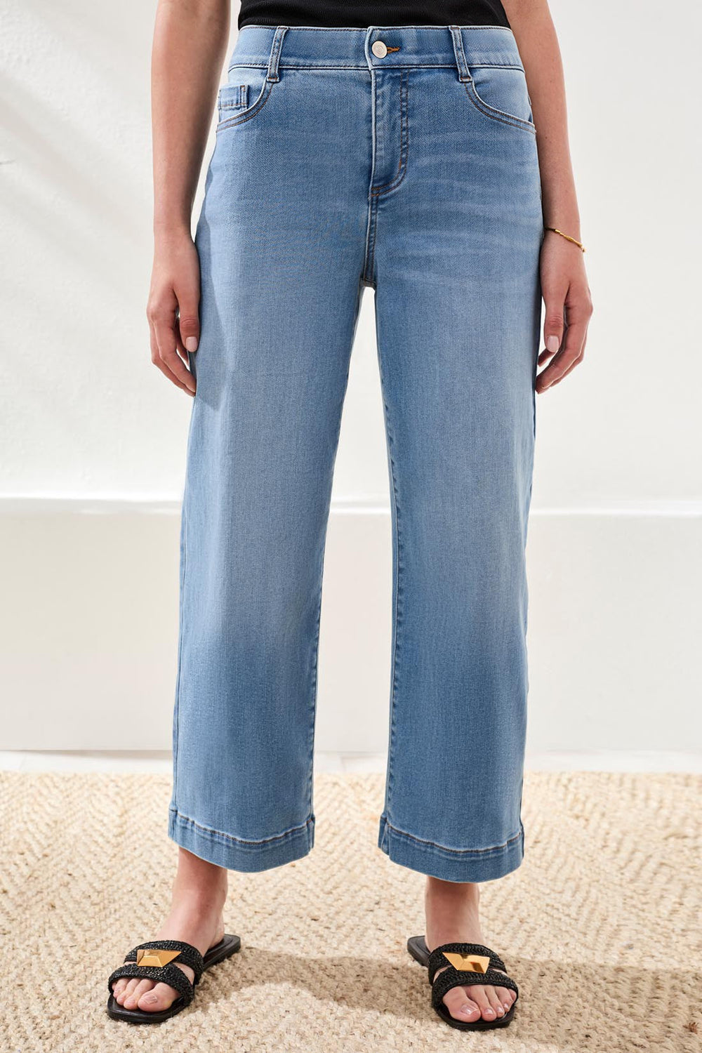 Woman wearing light blue wide-leg cropped denim jeans with cuffed hems