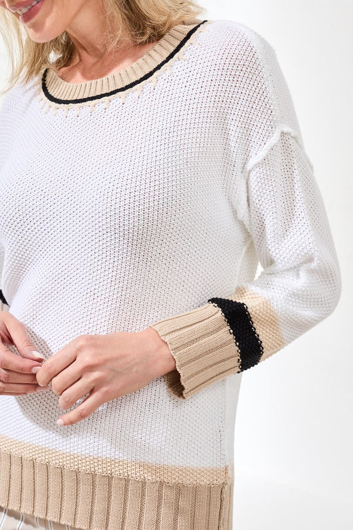 White knit crew neck sweater with tan ribbed trim and black accent stripes
