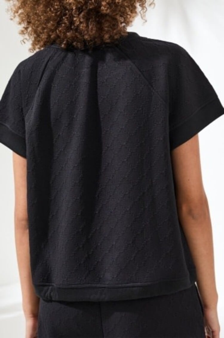 Black crew neck top with drawcord detail, short sleeves, back view on model