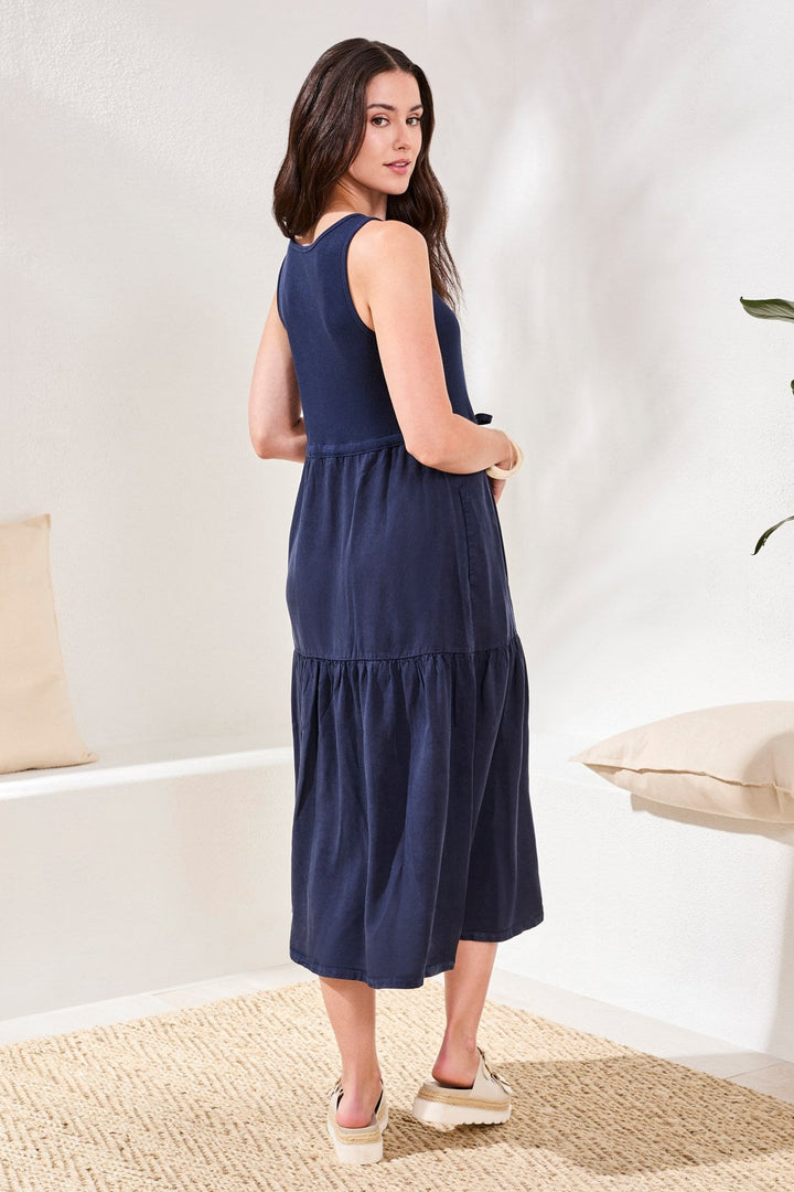 Navy blue sleeveless tiered midi dress with ruffle hem worn by model
