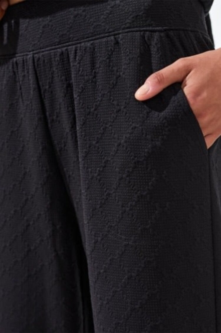 Black textured pull-on capri pants with side pockets, model wearing Tribal brand