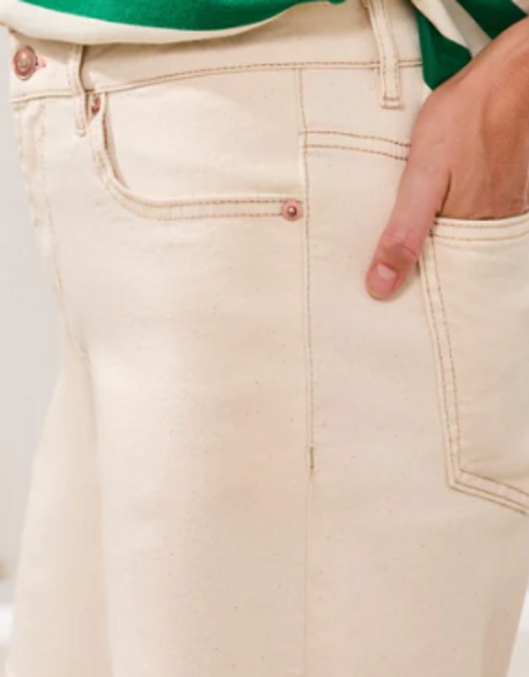 Cream colored denim shorts with hand in pocket, professional model shot