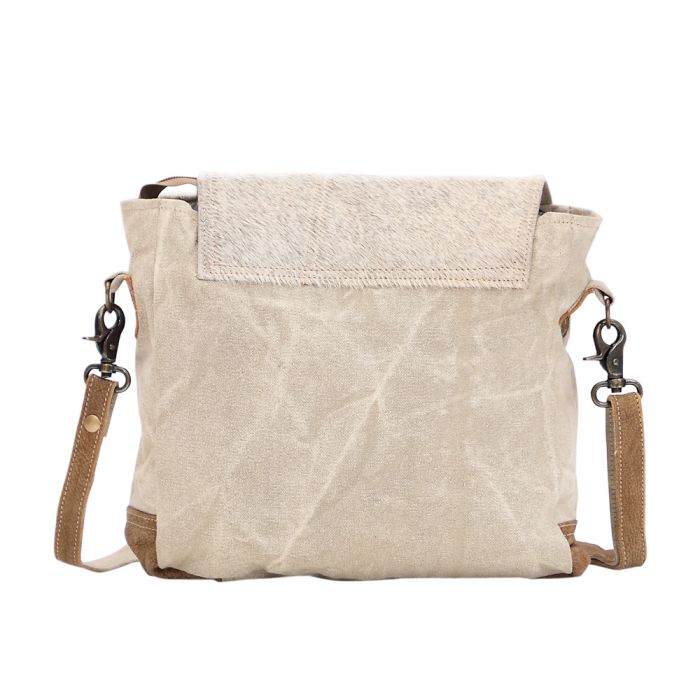 Messenger bag with canvas and hairon leather combo, side hairon accents, and secure top closure—rugged-chic for bold women 30+.









